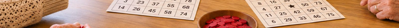 4 ausgedruckte Bingo Karten für Senioren liegen auf einem Tisch